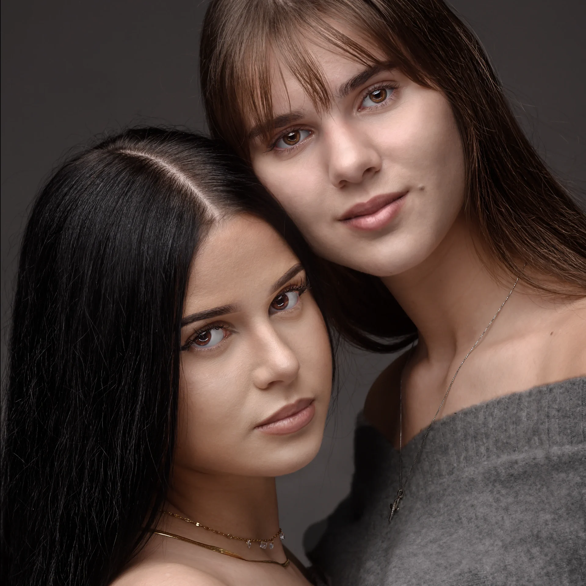 Ritratto di due giovani donne con capelli lunghi, una mora e una castana, vestite con maglie eleganti. Fotografia realizzata da Bruno Granzotti, fotografo a Pordenone